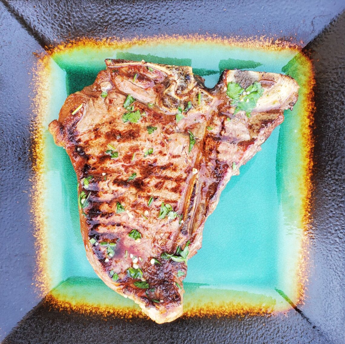 T-bone steak on a turquoise plate